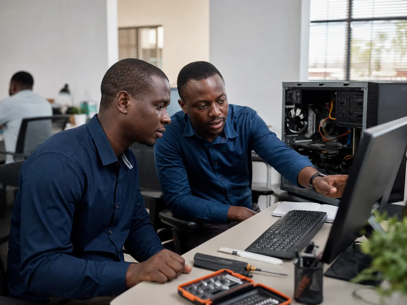 Technicien accompagnant un utilisateur pendant une opération de maintenance informatique